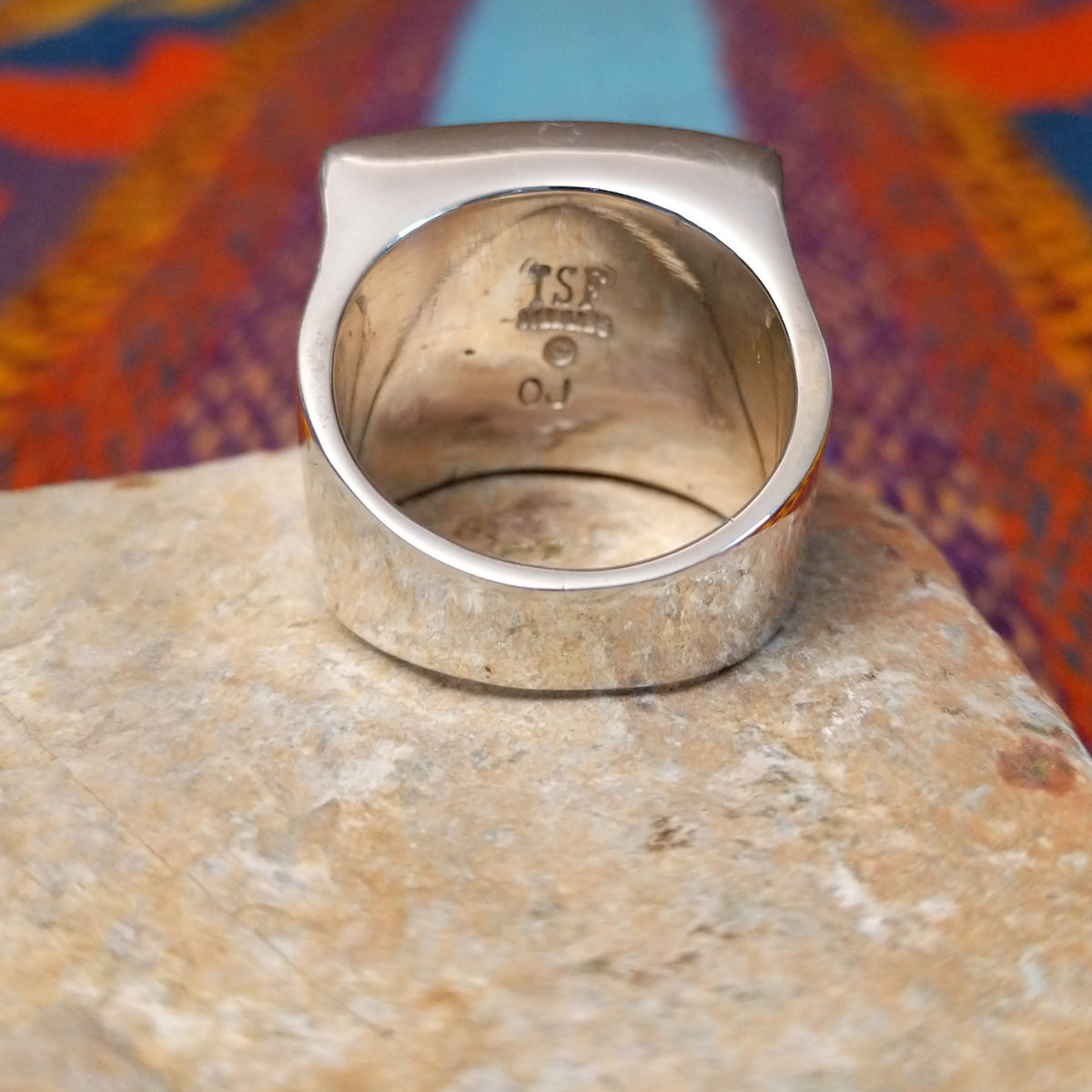 Multistone Square Inlay Ring by O.J. featuring colorful geometric turquoise, blue, red, yellow, and green stone inlay separated by Sterling Silver channels on a broad square face; underside view.