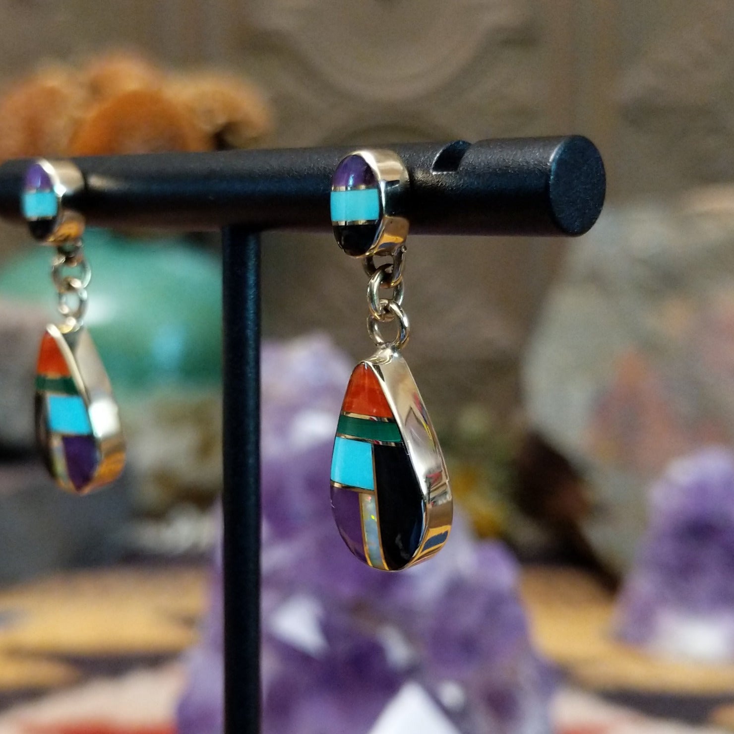 14kt gold Calvin Begay earrings with multistone teardrop inlay and oval tops.