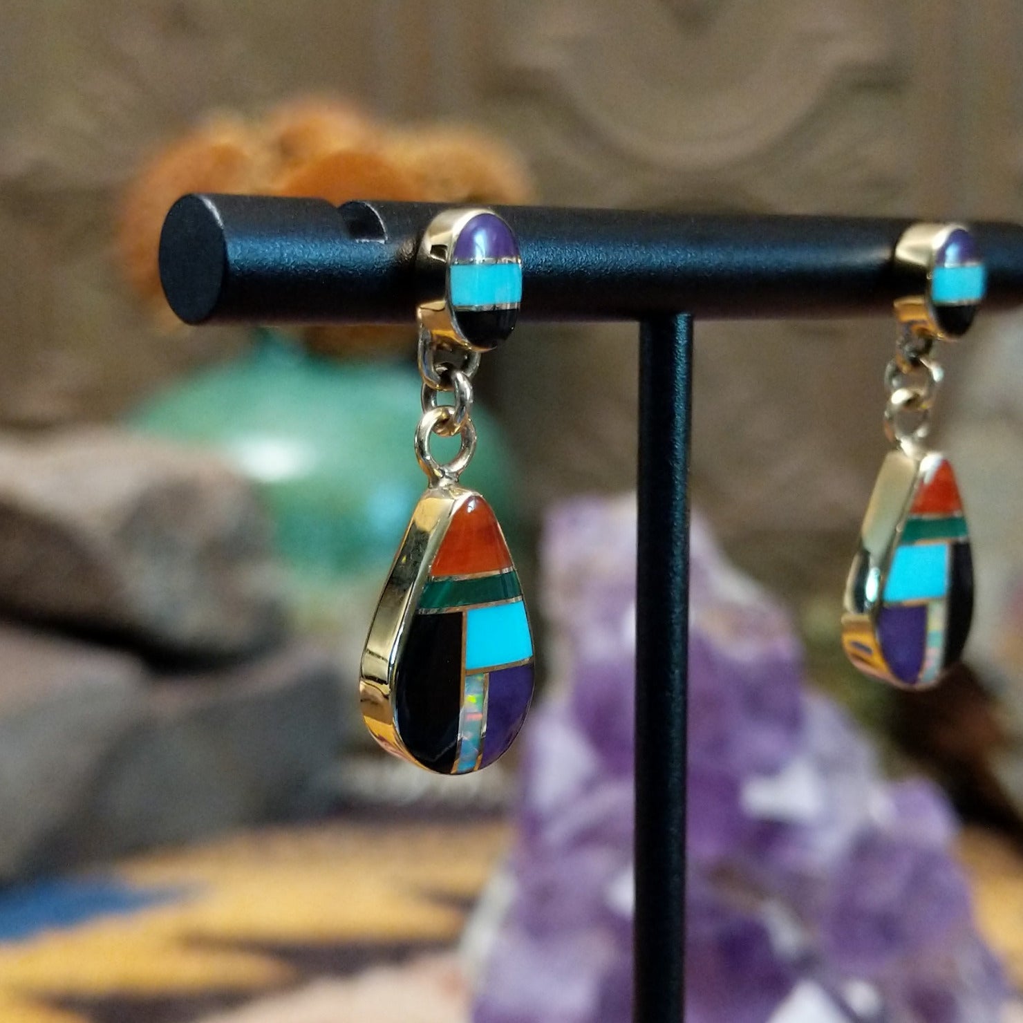 14kt gold Calvin Begay earrings with multistone teardrop inlay and oval tops.