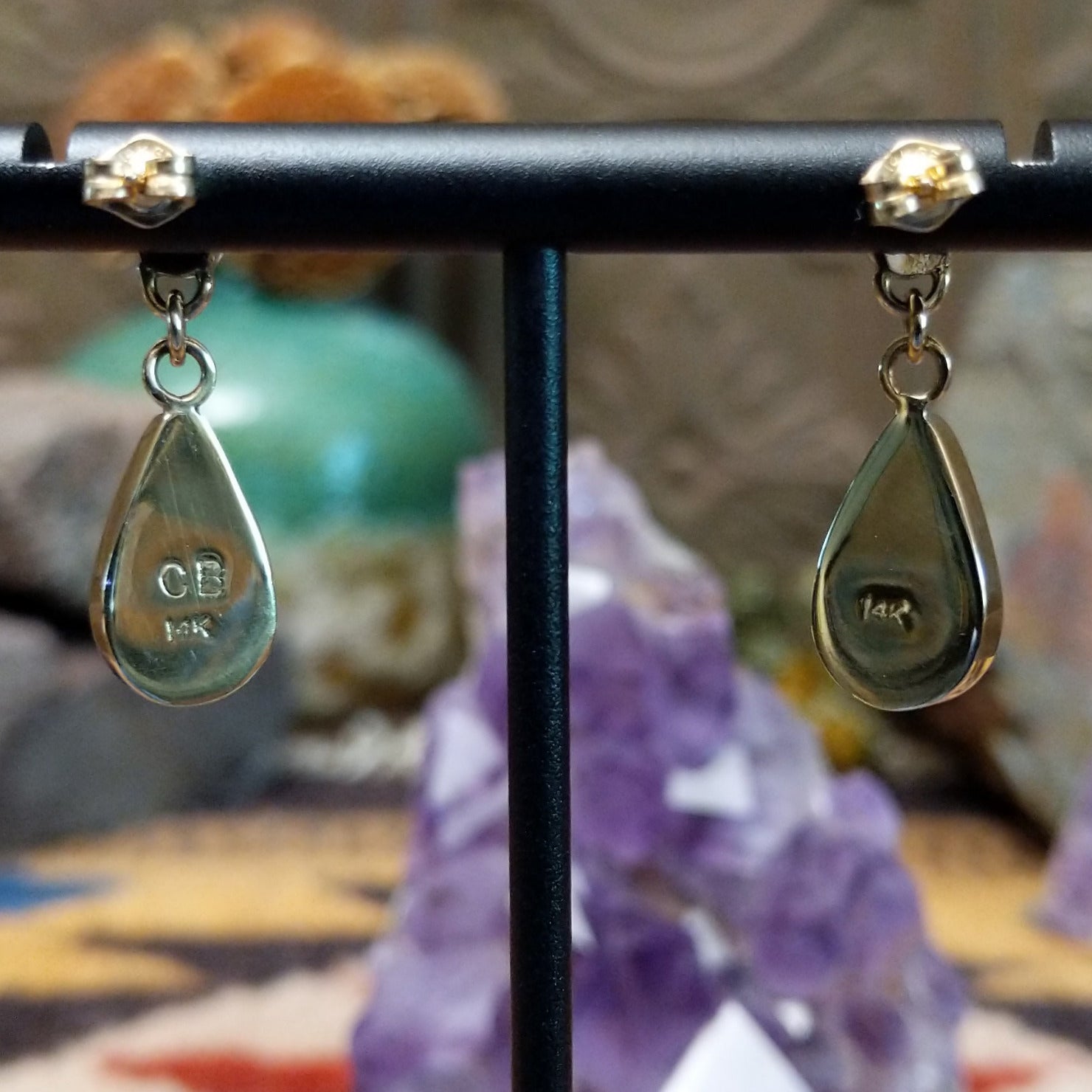 Close up of artist's stamped signature and 14K indicating 14 karat gold construction.