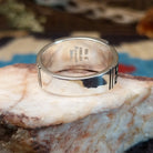 Sterling silver ring with multistone inlay and geometric stamping on the band.