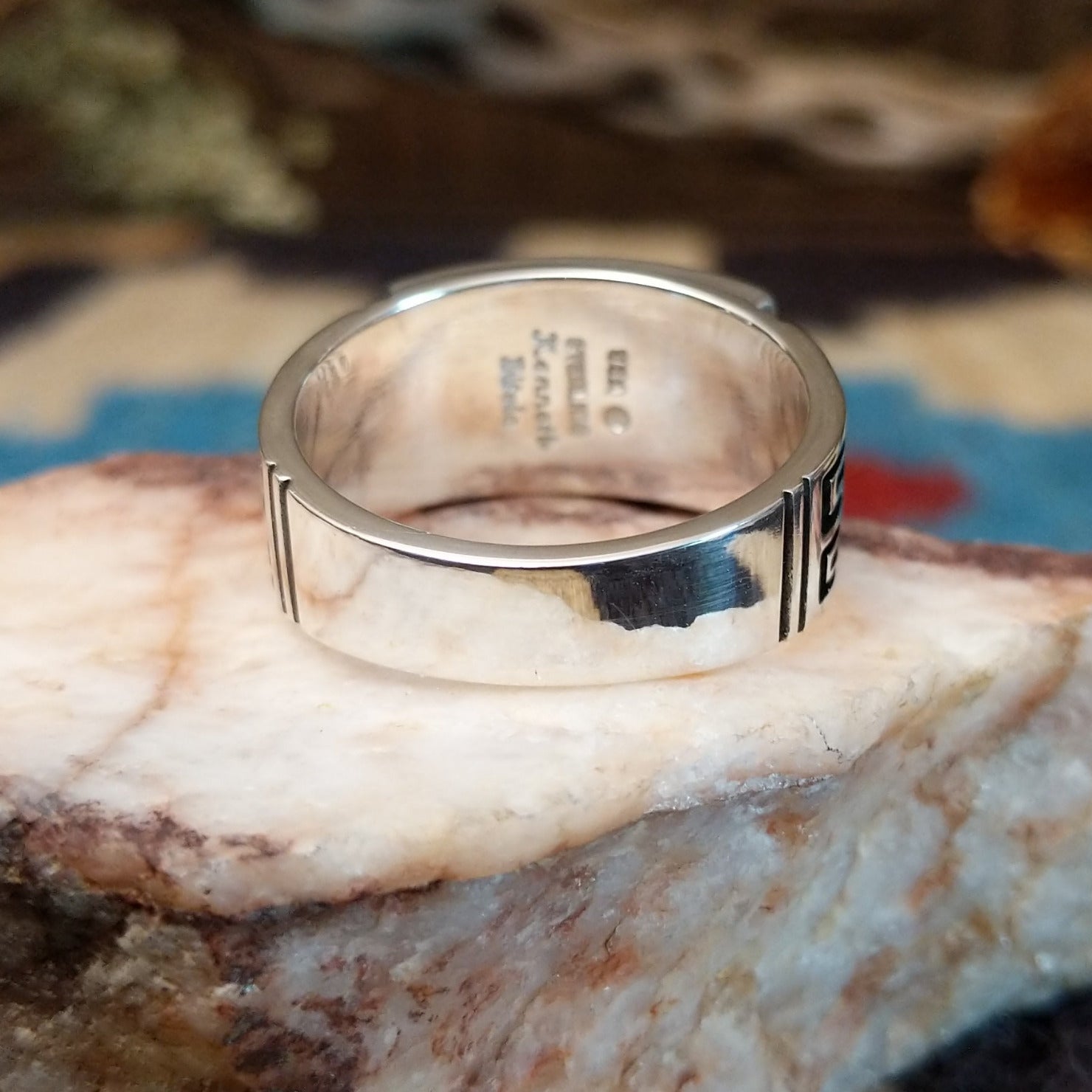 Sterling silver ring with multistone inlay and geometric stamping on the band.