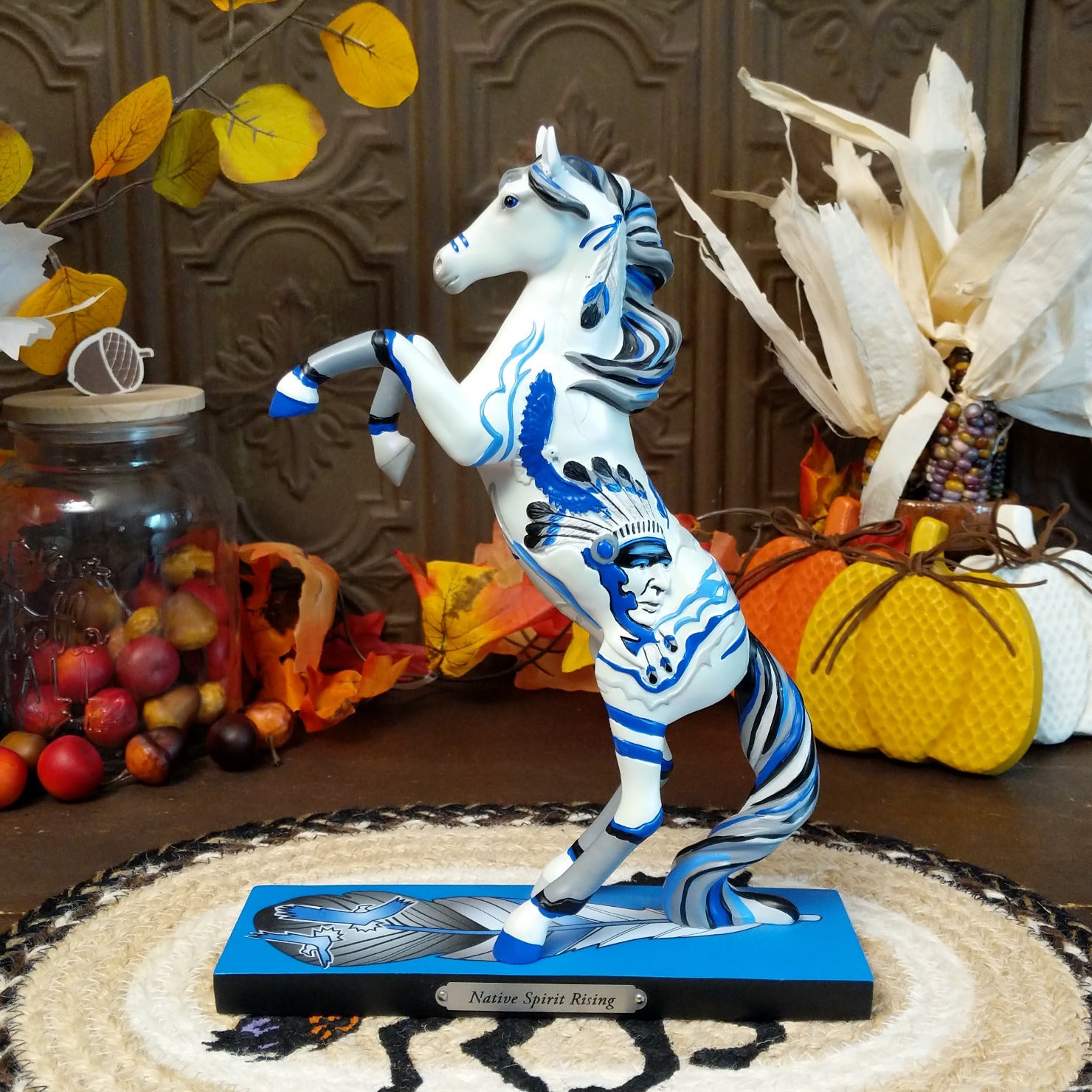 Resin pony painted white with Native American motif and contrasting blue paints.
