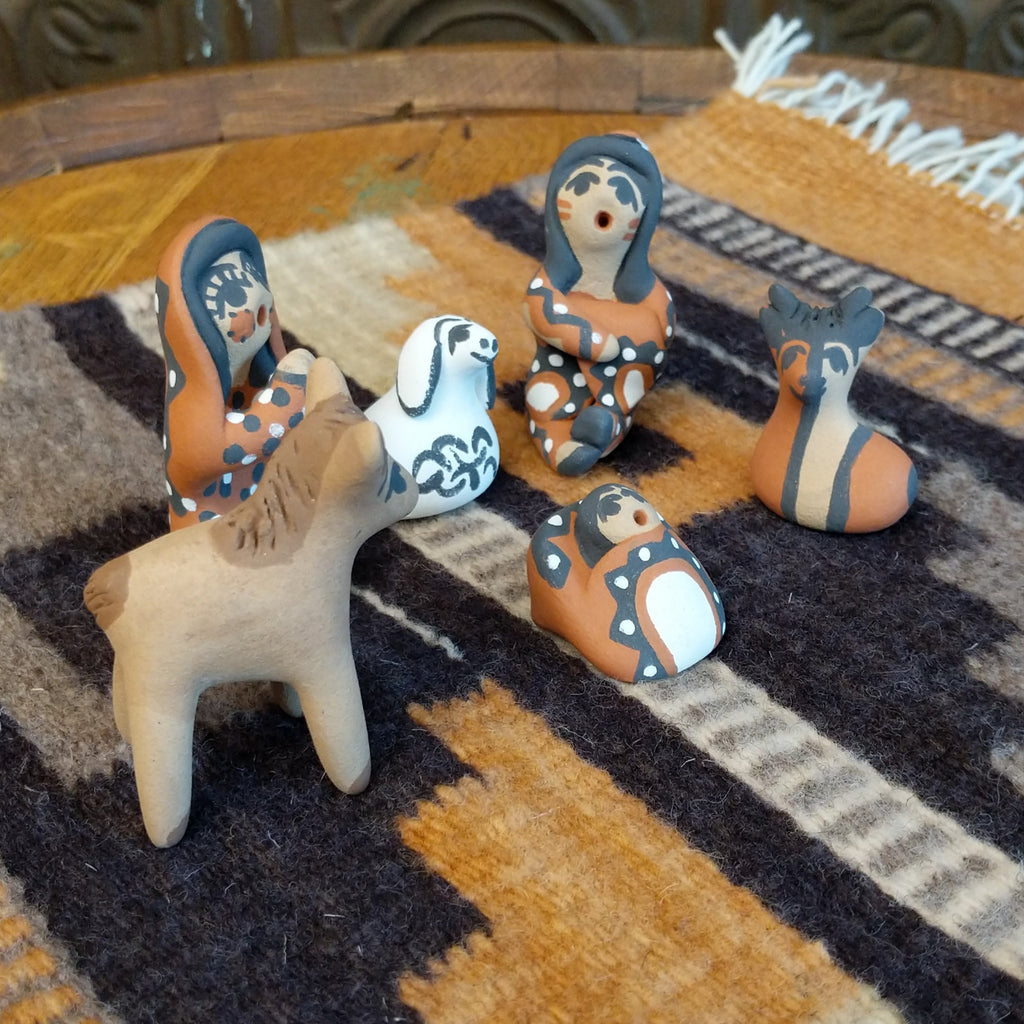 Clay sculpted into a nativity scene and painted in the colors brown, black, white, and terracotta.