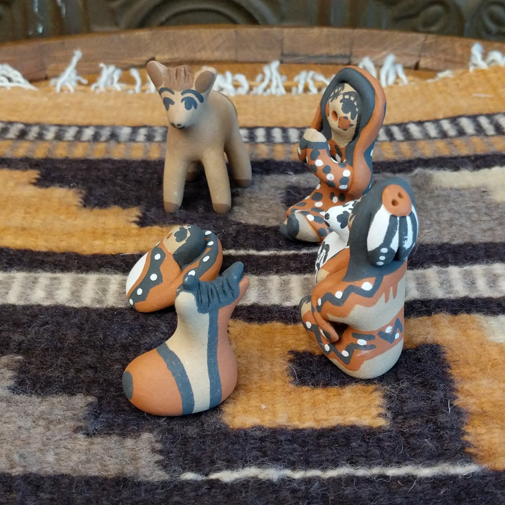 Clay sculpted into a nativity scene and painted in the colors brown, black, white, and terracotta.