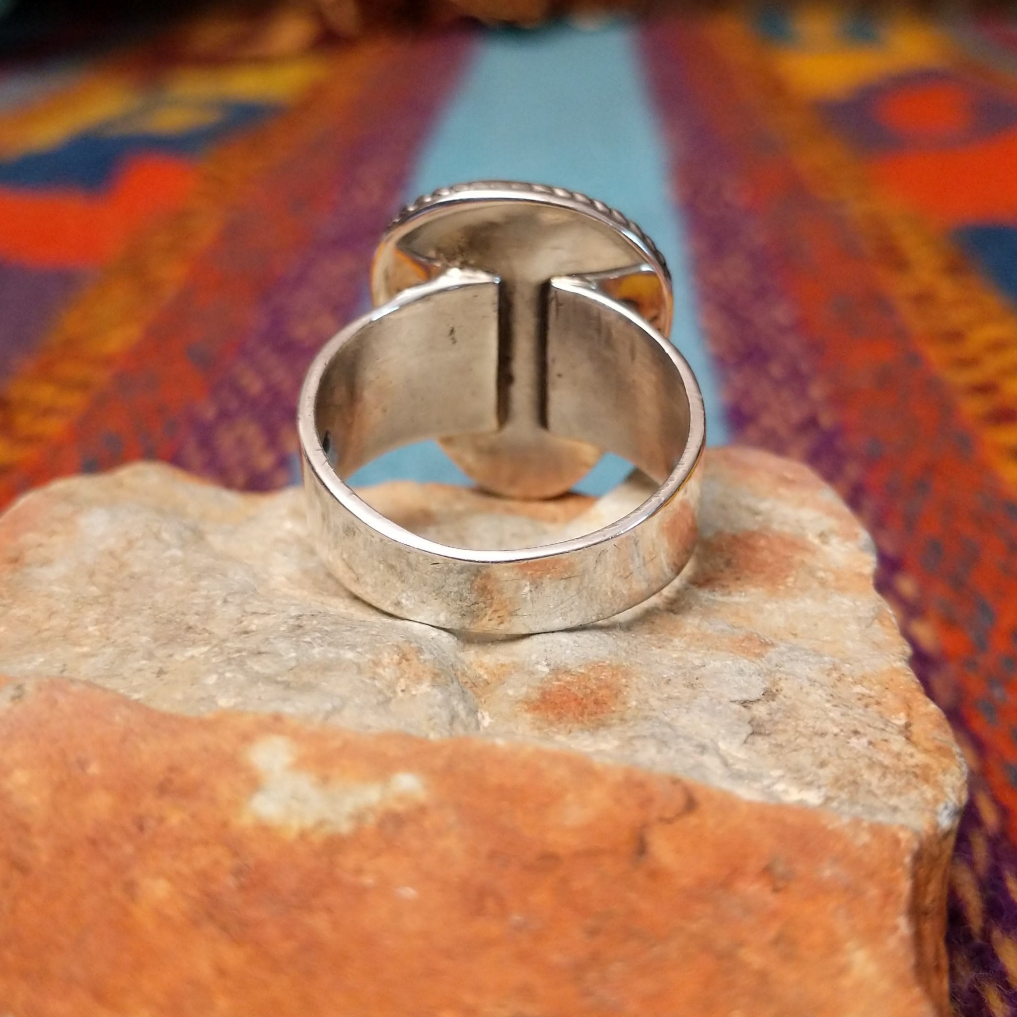 Navajo #8 Turquoise Ring featuring a large freeform blue turquoise cabochon with prominent brown matrix, framed by twisted silver rope detailing in a polished silver setting; underside view.