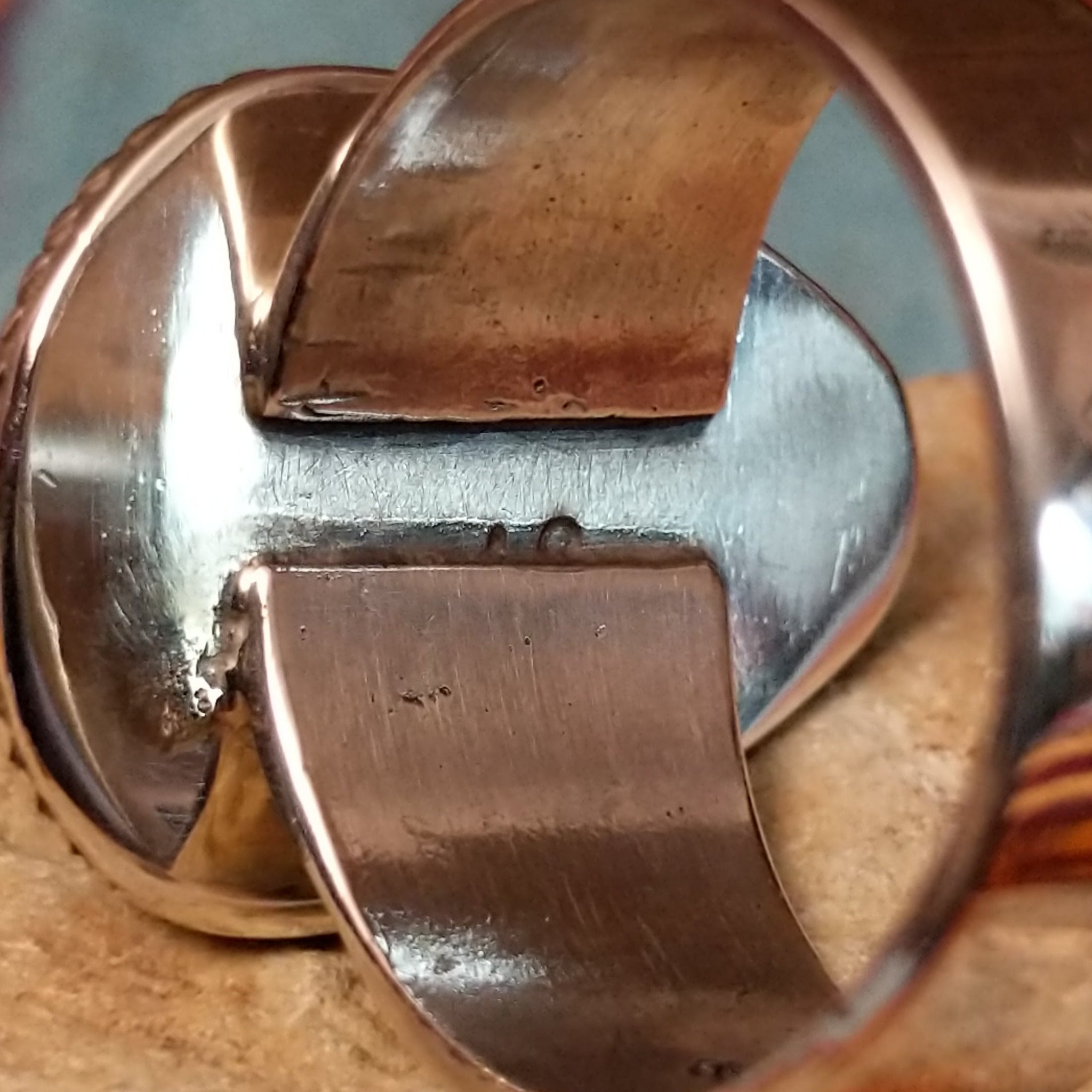 Navajo #8 Turquoise Ring featuring a large freeform blue turquoise cabochon with prominent brown matrix, framed by twisted silver rope detailing in a polished silver setting; artisan stamp.