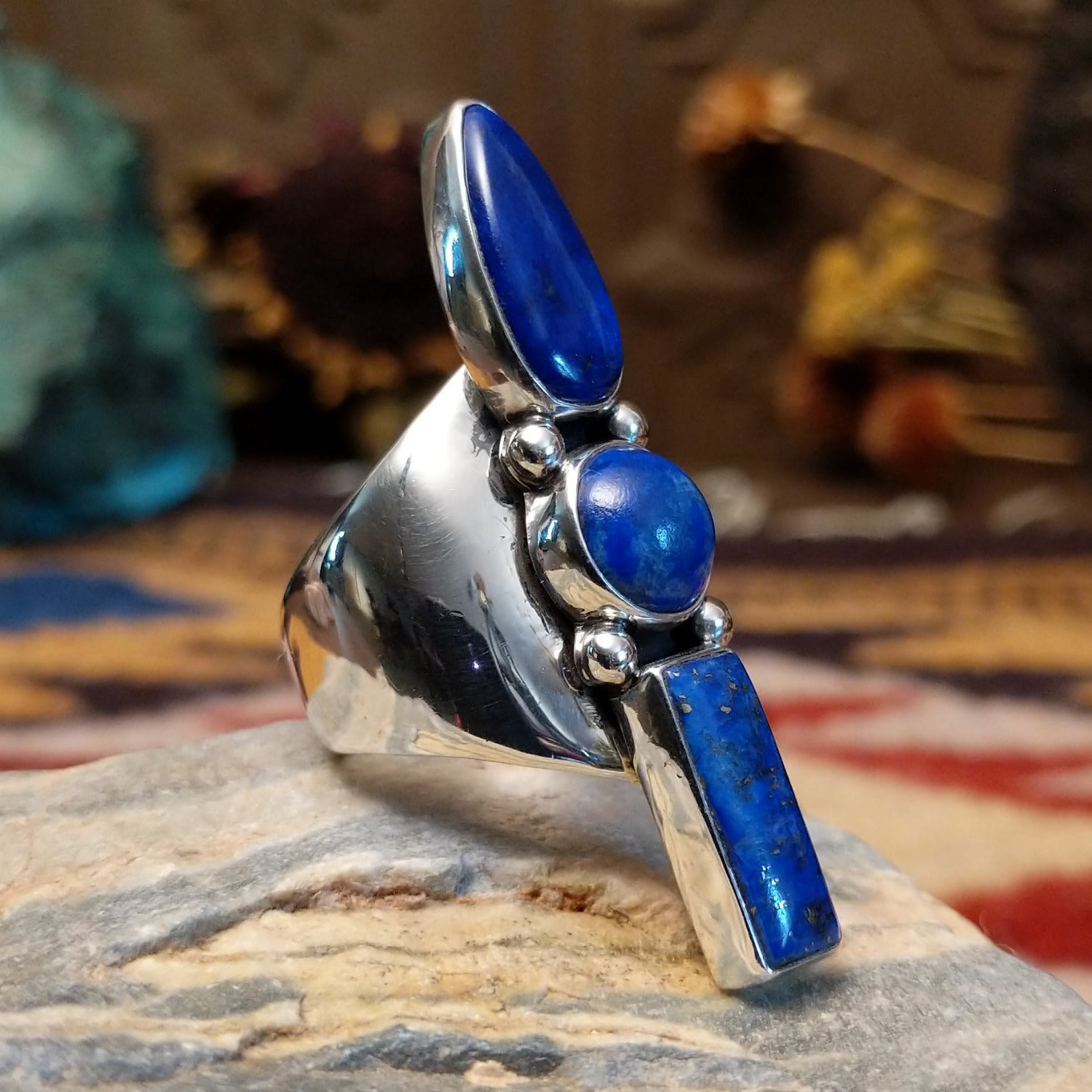 Handcrafted Navajo sterling silver ring by V.T. featuring a deep blue lapis stone in an abstract Southwestern design with intricate silver detailing.  Side view.
