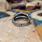 Navajo sterling silver ring with a hand-stamped floral design and polished silver accents; underside view.