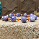 Beaded charoite bracelet with accents of sterling silver and orange spiny oyster shell.