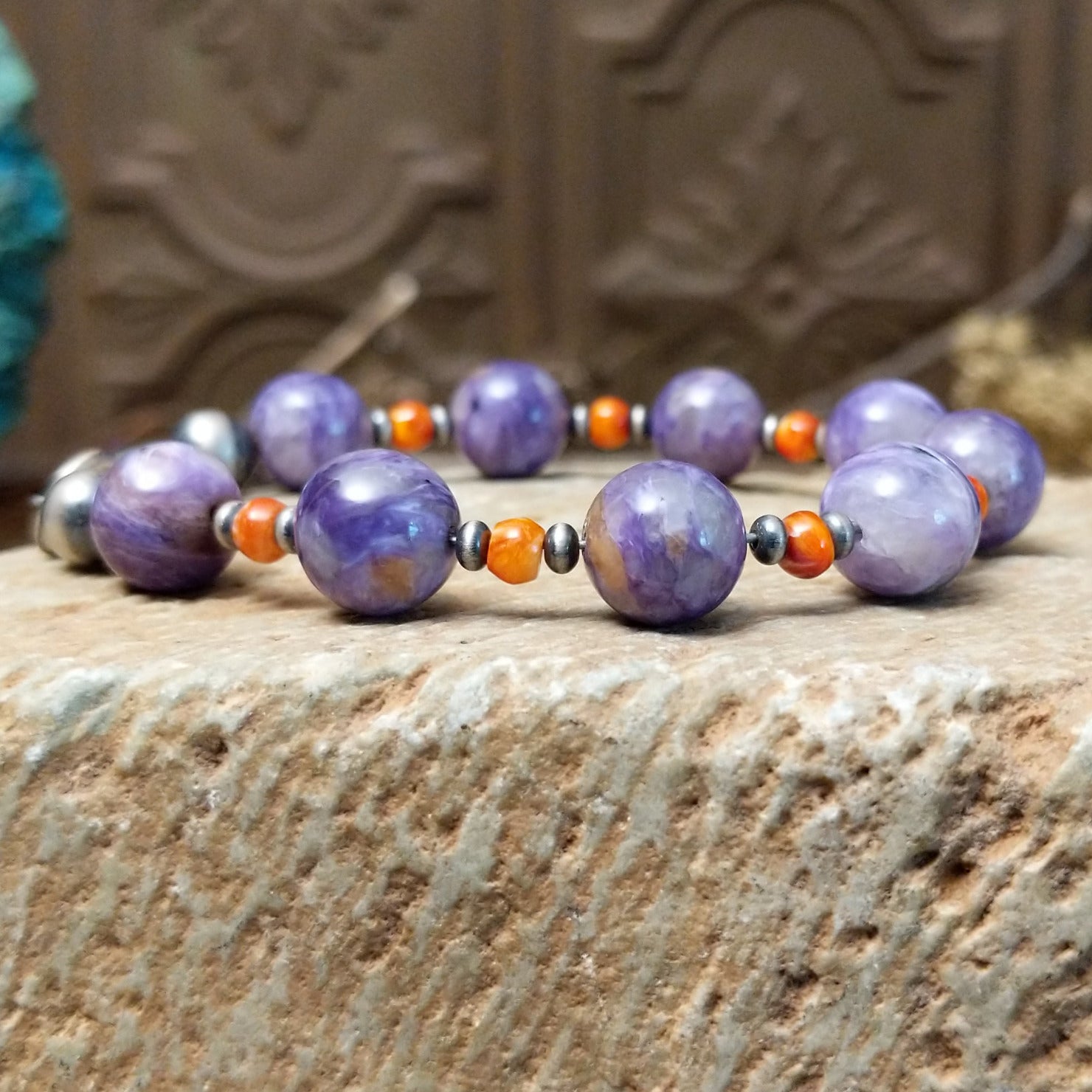 Beaded charoite bracelet with accents of sterling silver and orange spiny oyster shell.