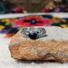 Refined Navajo Black Onyx Feather Ring featuring a polished oval black onyx stone set in sterling silver with detailed feather-inspired silverwork along the band.