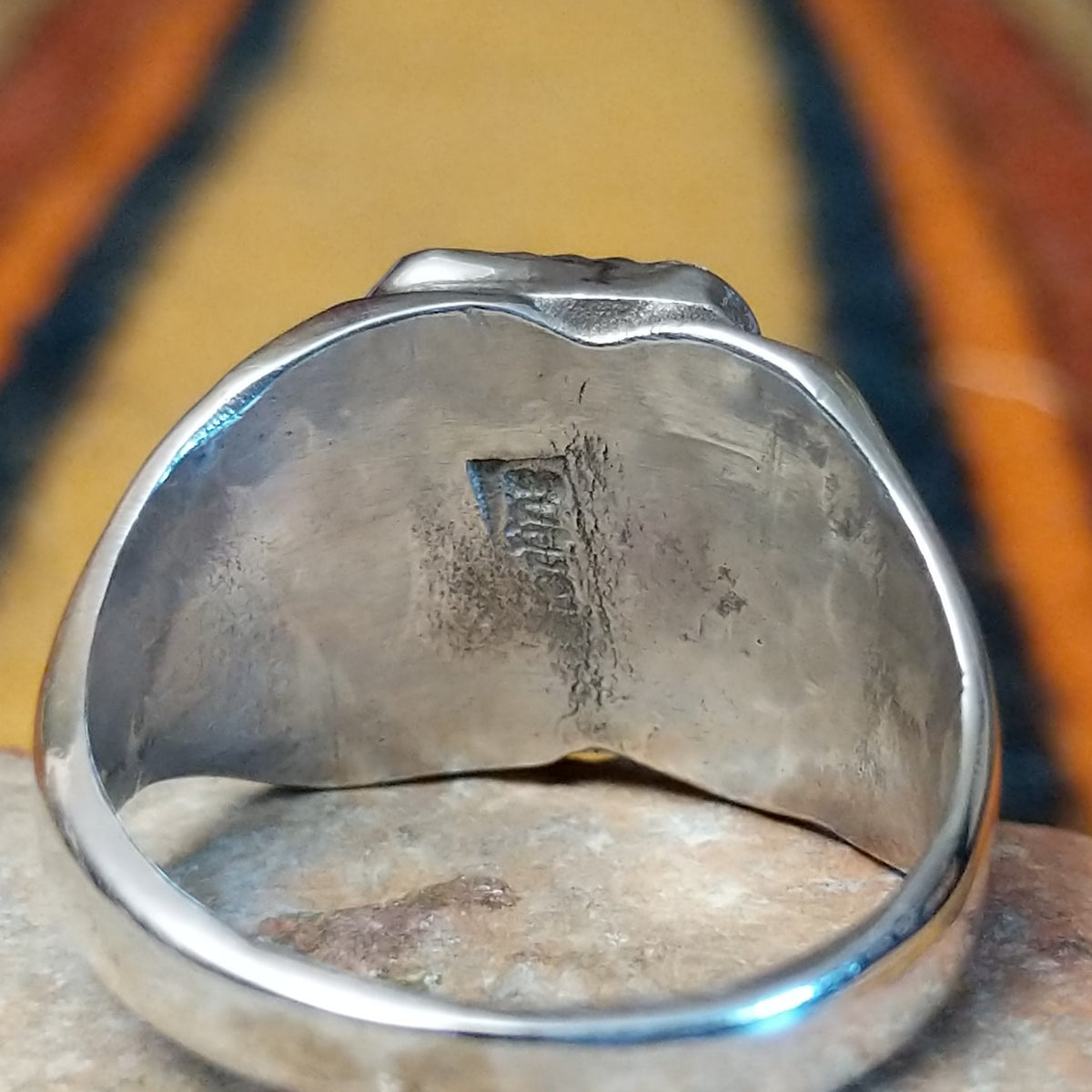 Navajo Black Onyx Ring featuring a polished rectangular black onyx gemstone in a sawtooth silver bezel, with a wide silver band accented by stamped fan-shaped designs on both sides; Sterling Silver stamp.