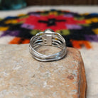 Navajo silver ring with polished black onyx and a multi-strand wavy band.