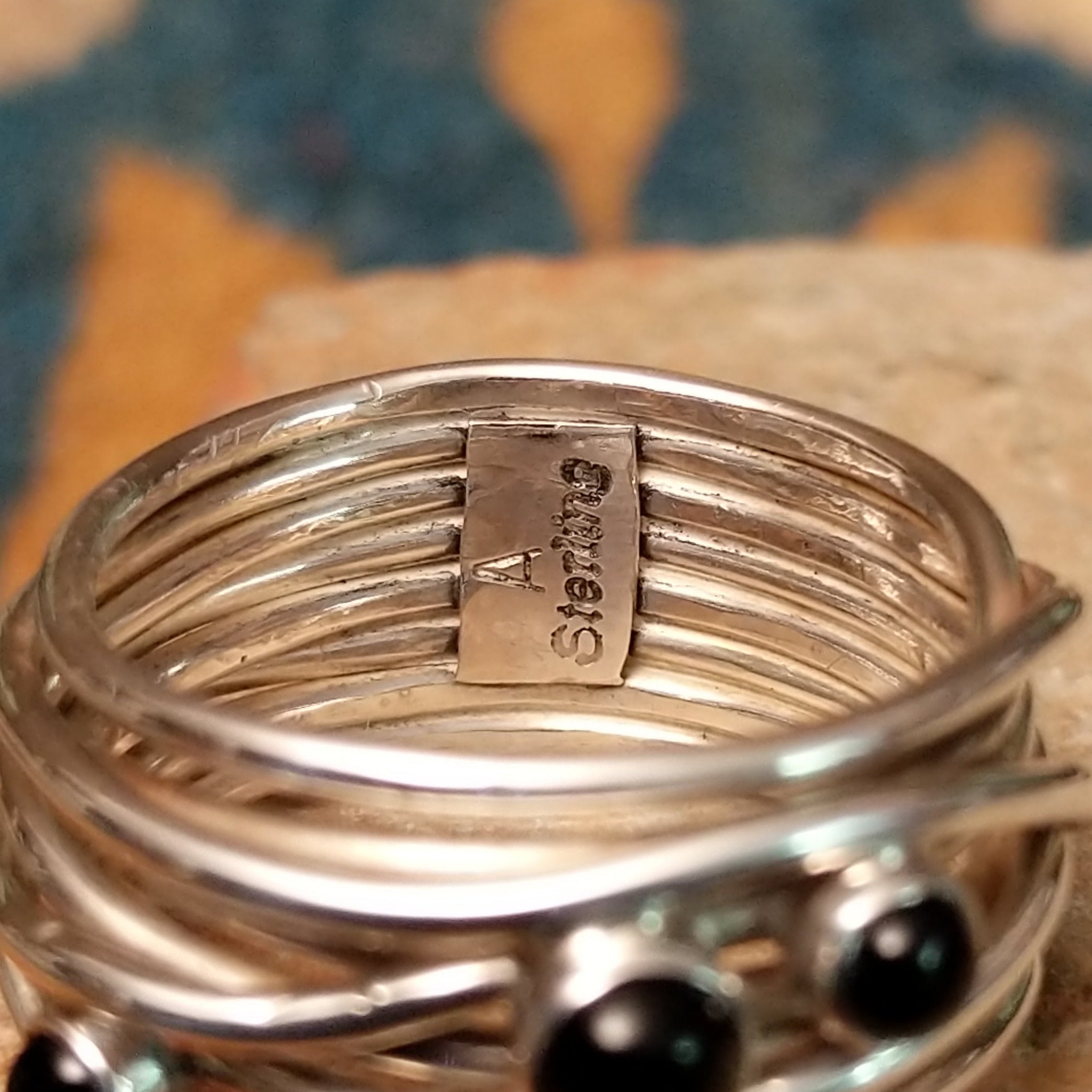 Navajo sterling silver multi-strand ring with polished Black Onyx cabochons; artisan and Sterling Silver stamp.
