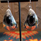 Sterling silver earrings with black onyx set in oval bezels, framed by the wavey silver settings and lined stamping.