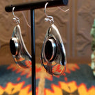 Sterling silver earrings with black onyx set in oval bezels, framed by the wavey silver settings and lined stamping.
