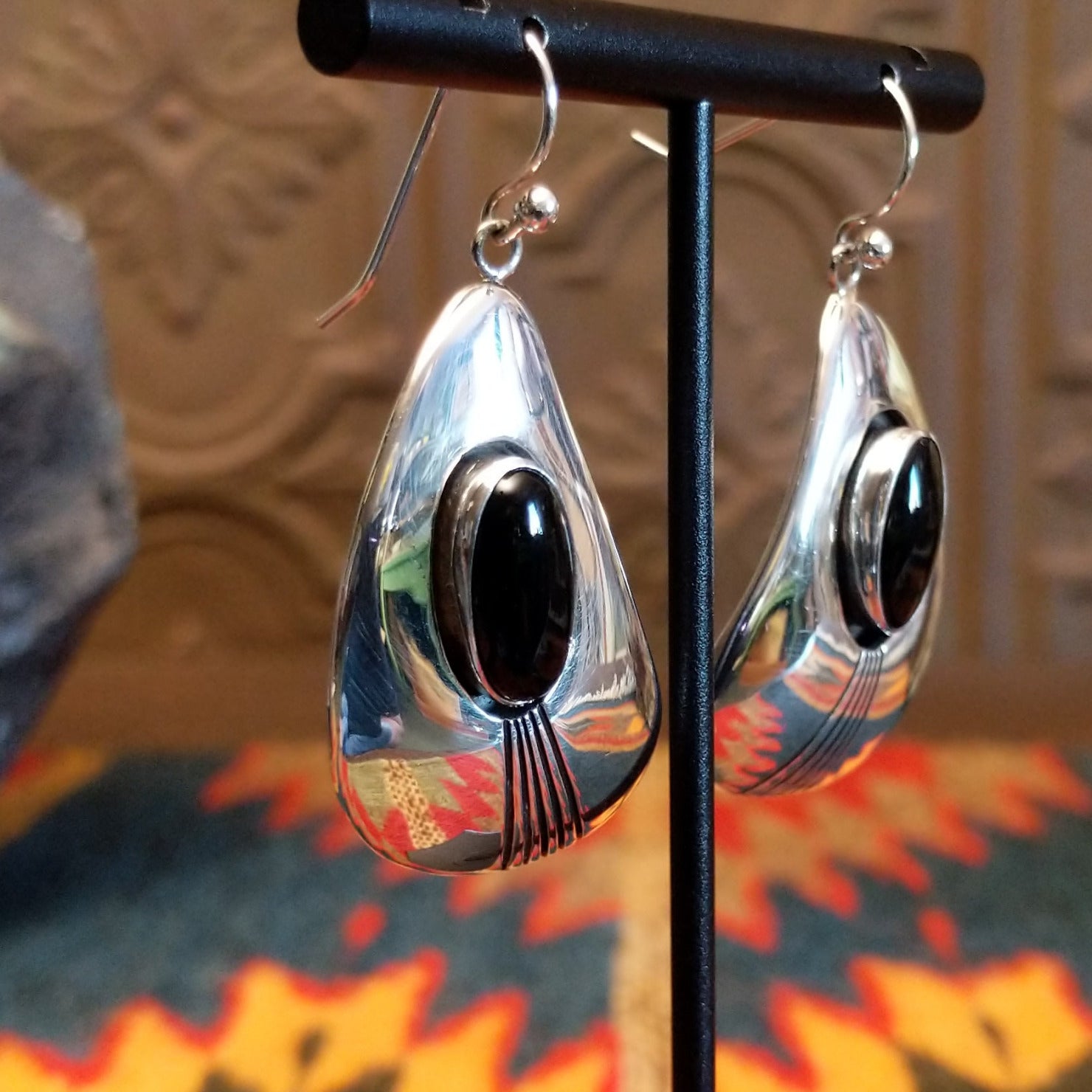 Sterling silver earrings with black onyx set in oval bezels, framed by the wavey silver settings and lined stamping.