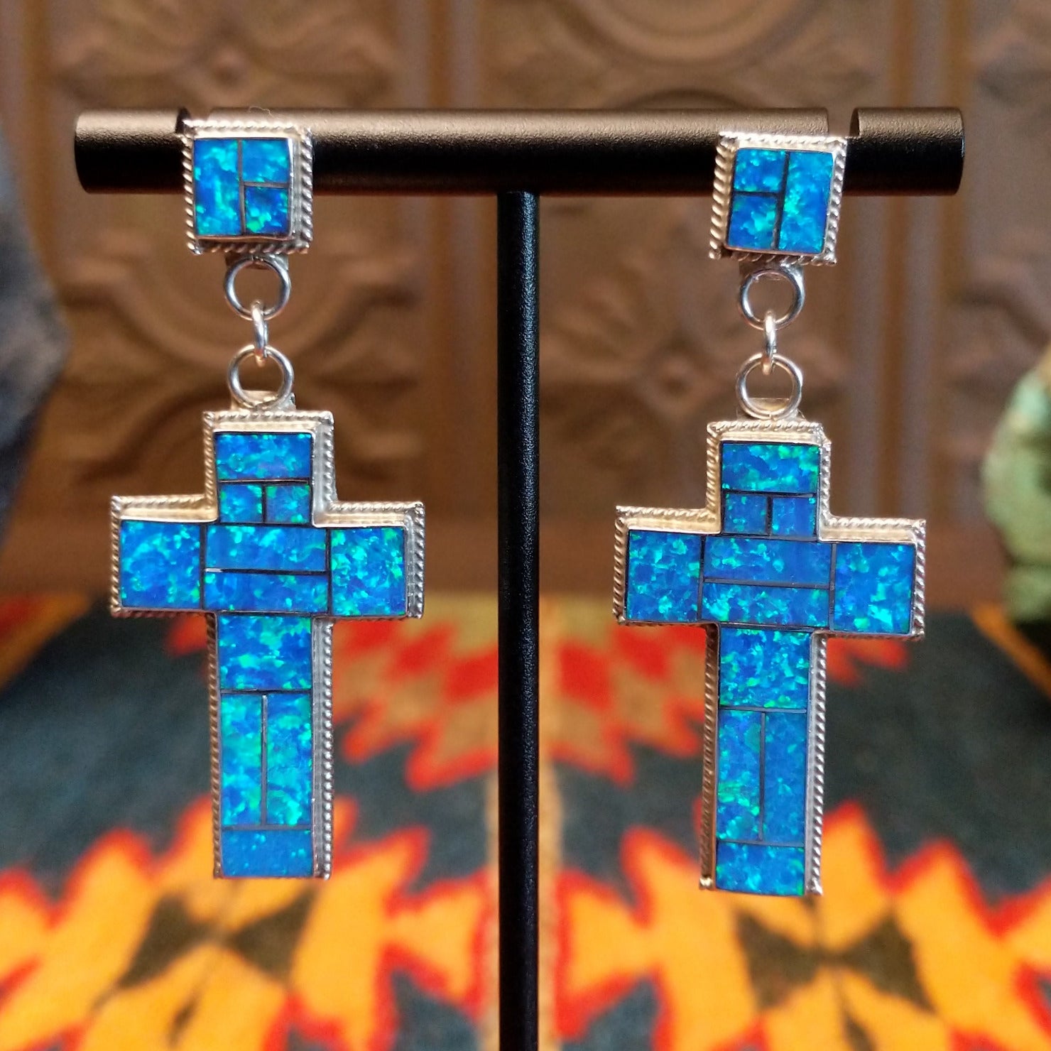Sterling silver earrings with blue manmade opal inlaid in the cross settings.