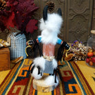 Back view of the Navajo Buffalo Dancer Kachina doll with black horns, thick white fur, black-and-white painted details, and blue shoulder accents.
