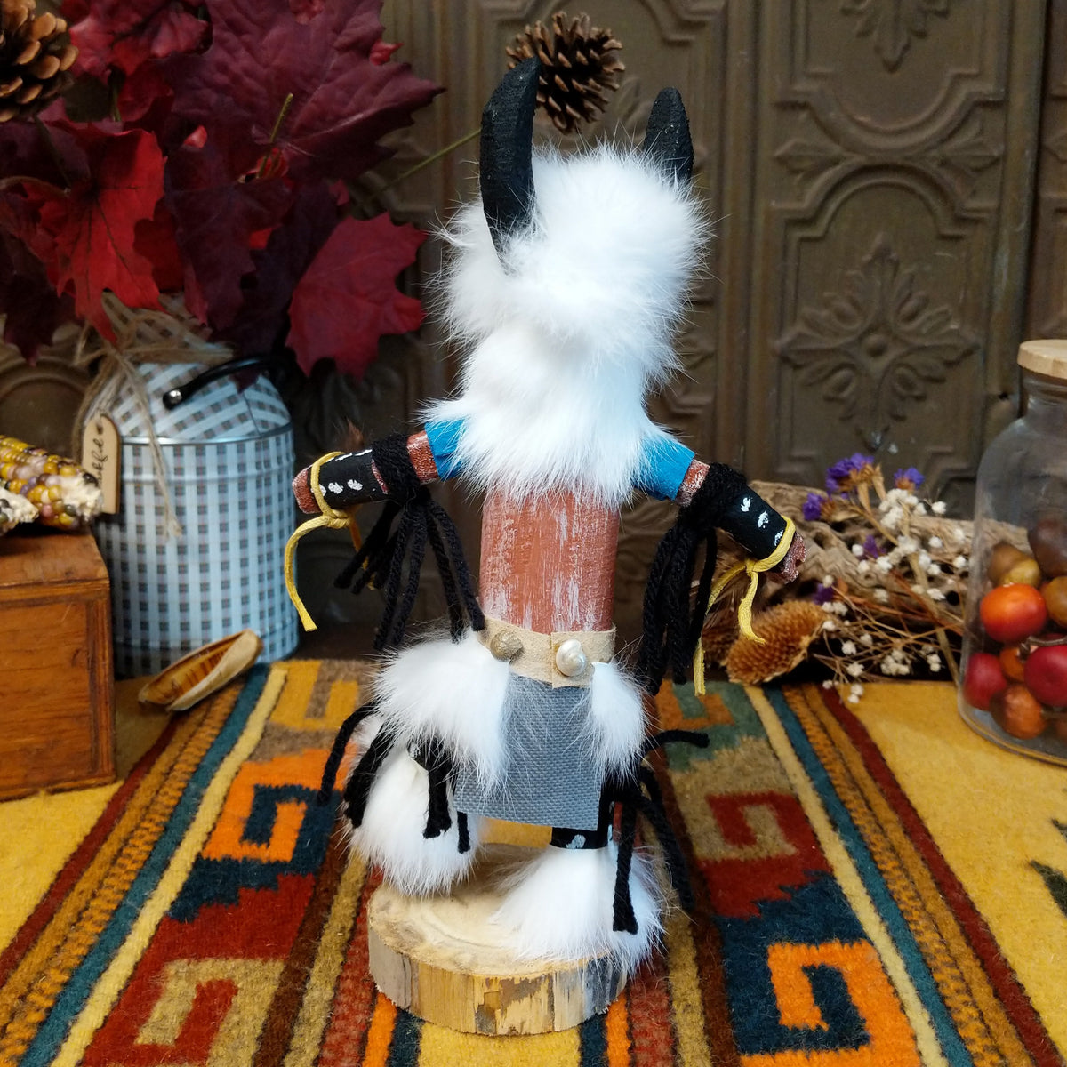 Back view of the Navajo Buffalo Dancer Kachina doll with black horns, thick white fur, black-and-white painted details, and blue shoulder accents.