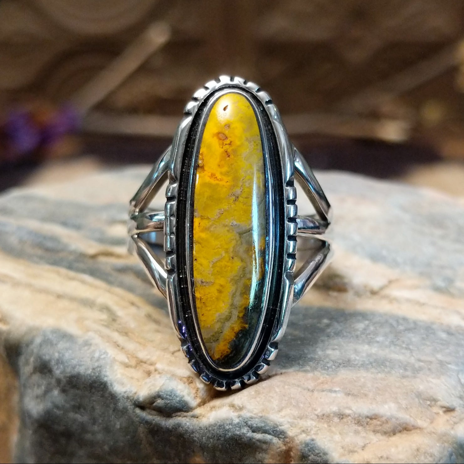 Sterling silver ring with bumblebee jasper set in a capsule bezel, framed by incised designs.
