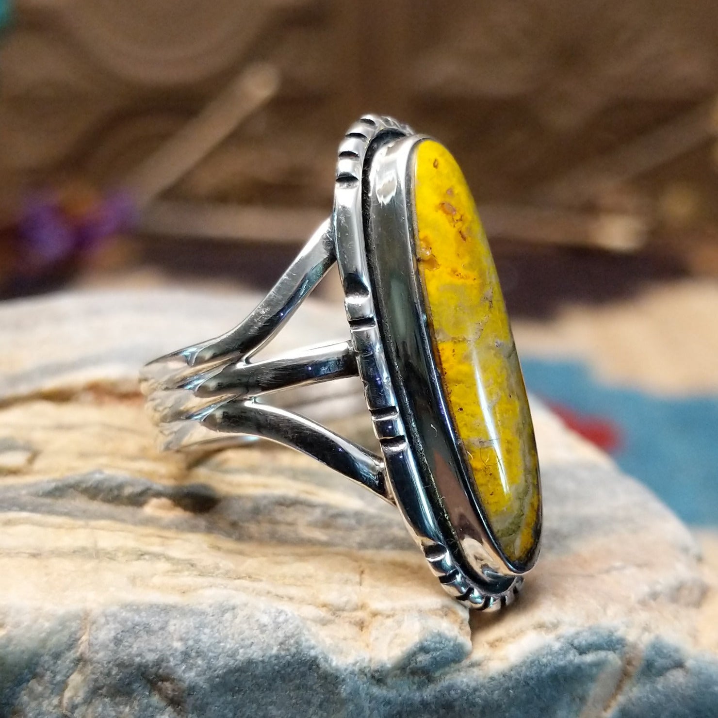 Sterling silver ring with bumblebee jasper set in a capsule bezel, framed by incised designs.
