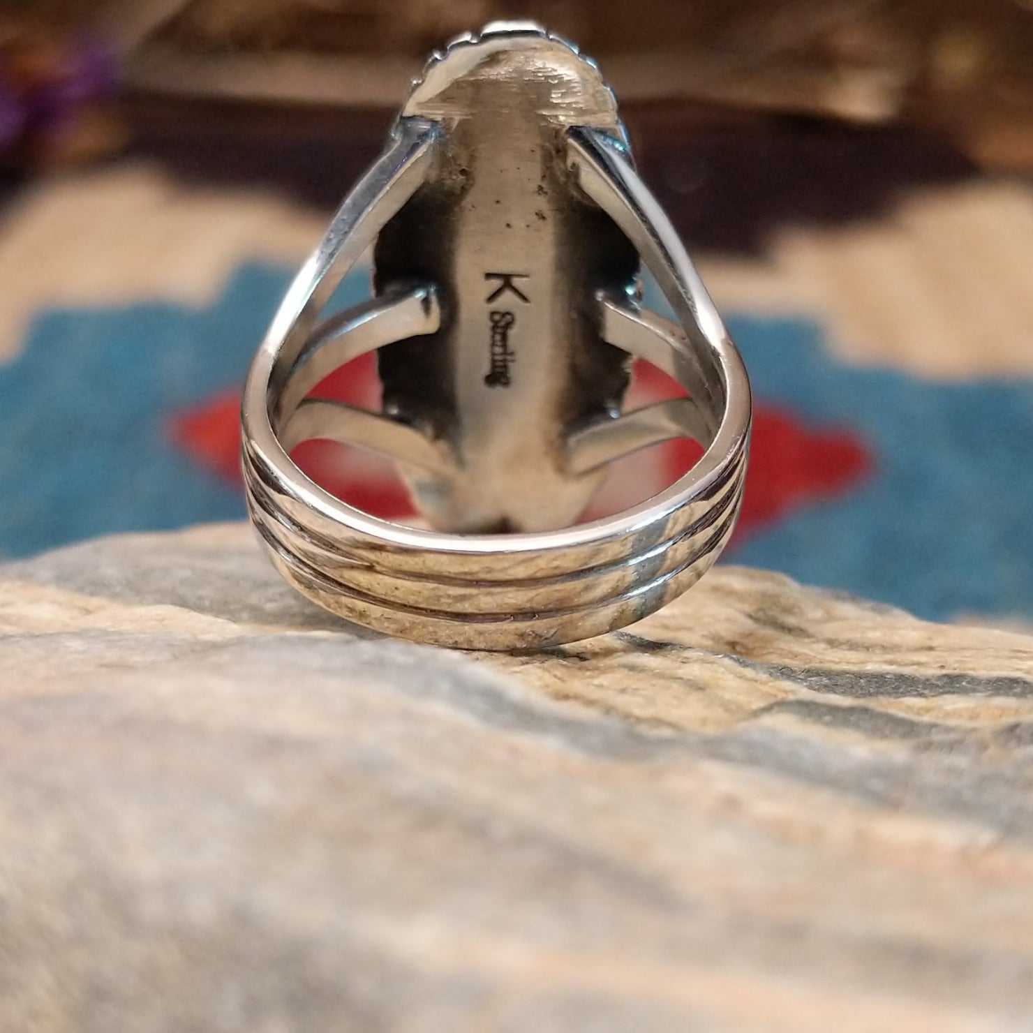 Sterling silver ring with bumblebee jasper set in a capsule bezel, framed by incised designs.