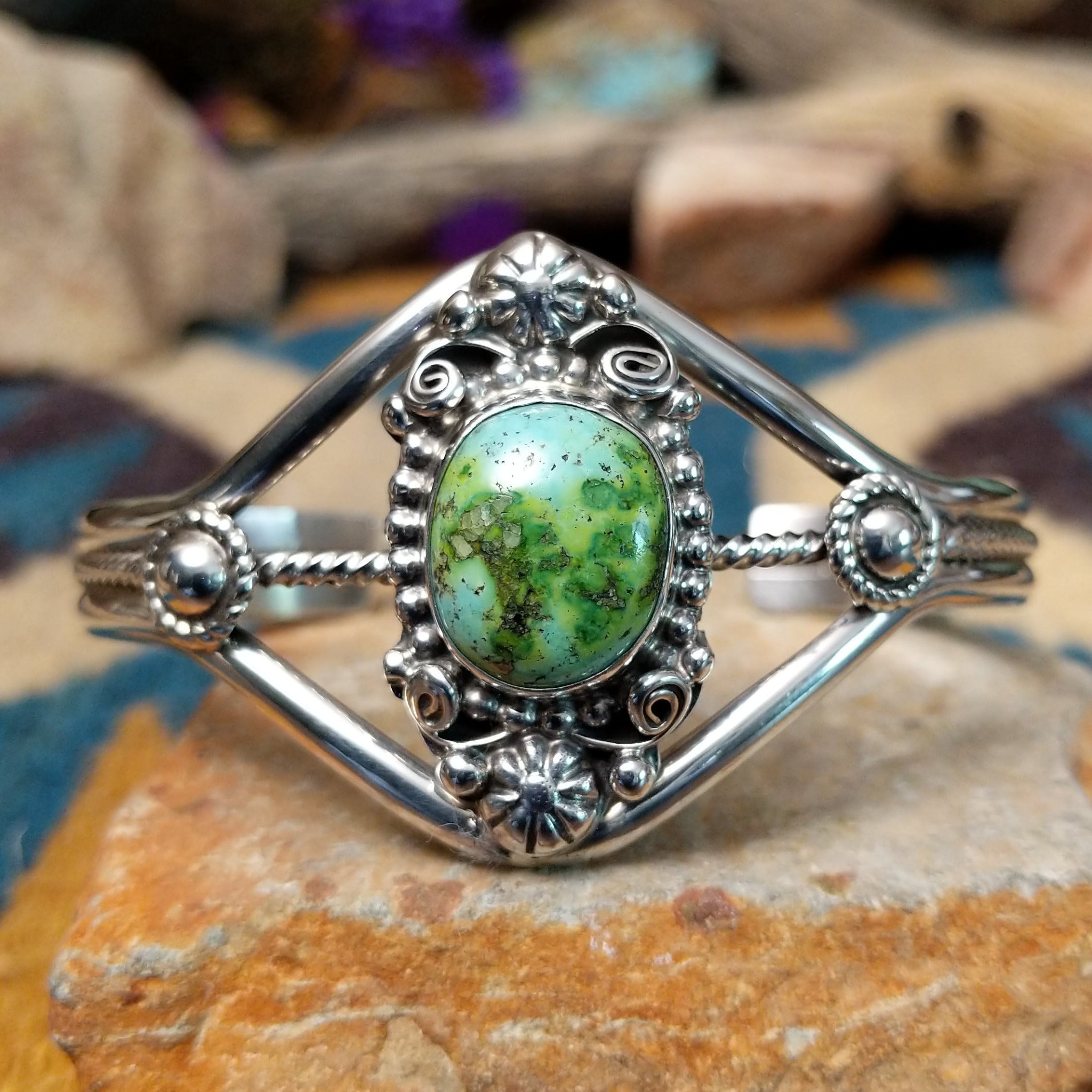 Handcrafted Navajo sterling silver cuff featuring an oval Carico Lake turquoise cabochon surrounded by ornate silver beadwork, scroll accents, and an open diamond-shaped frame.