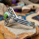 Handcrafted Navajo sterling silver cuff featuring an oval Carico Lake turquoise cabochon surrounded by ornate silver beadwork, scroll accents, and an open diamond-shaped frame.