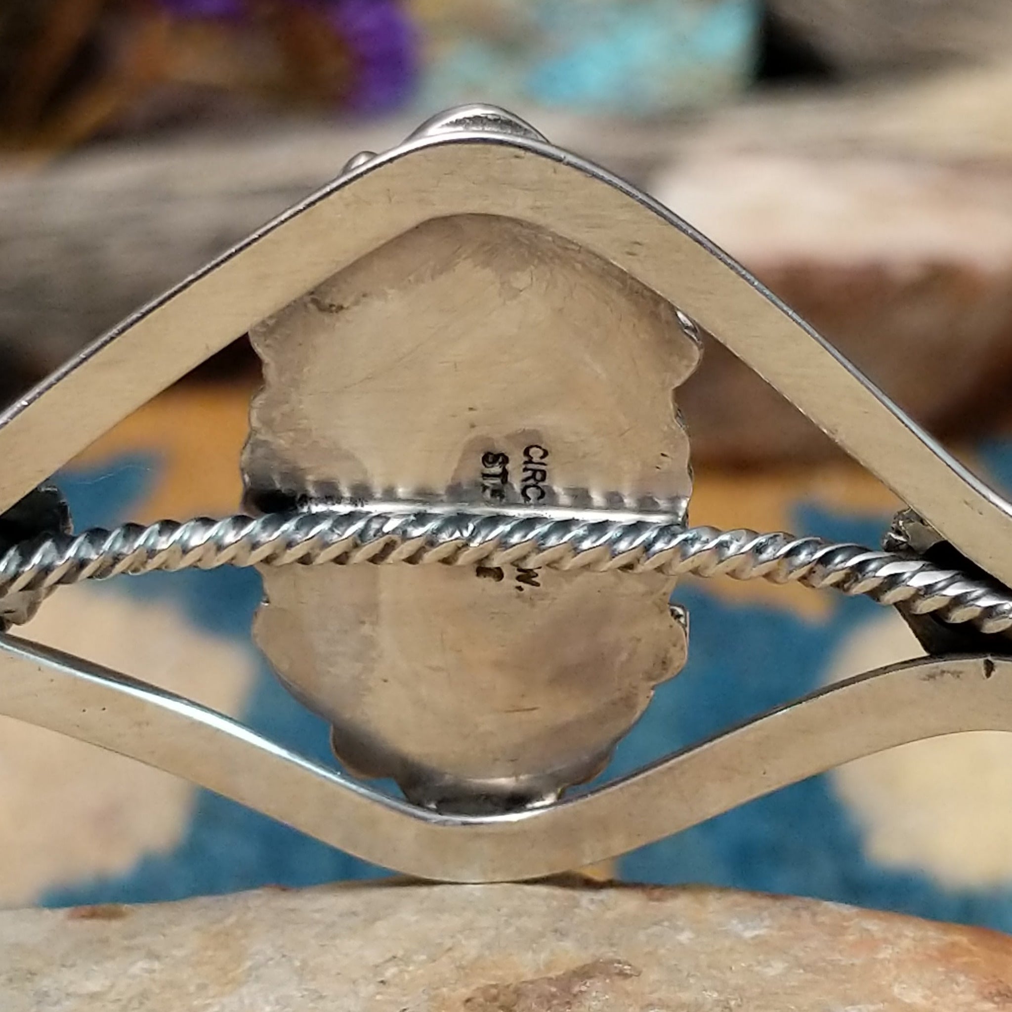 Handcrafted Navajo sterling silver cuff featuring an oval Carico Lake turquoise cabochon surrounded by ornate silver beadwork, scroll accents, and an open diamond-shaped frame; artisan and Sterling Silver stamp.