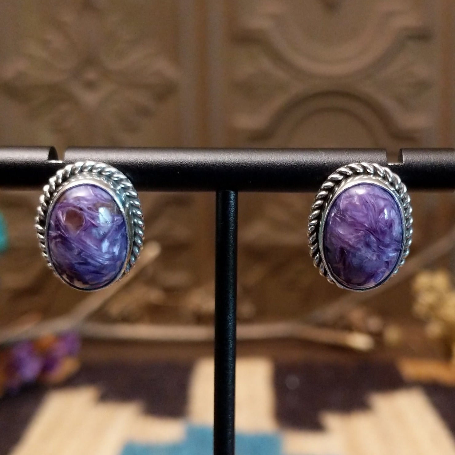 Sterling silver earrings with charoite set in oval bezels, framed by twisted rope accents.