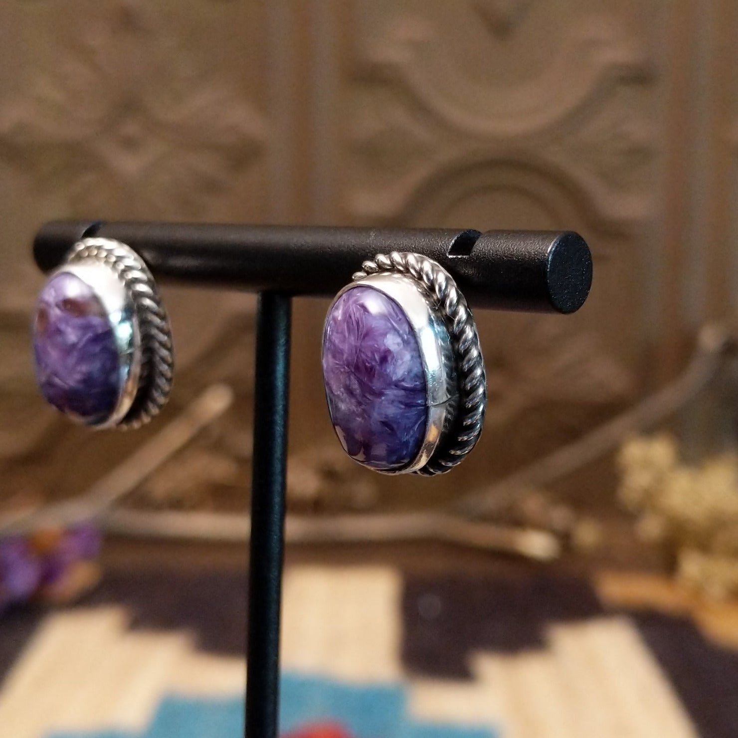Sterling silver earrings with charoite set in oval bezels, framed by twisted rope accents.