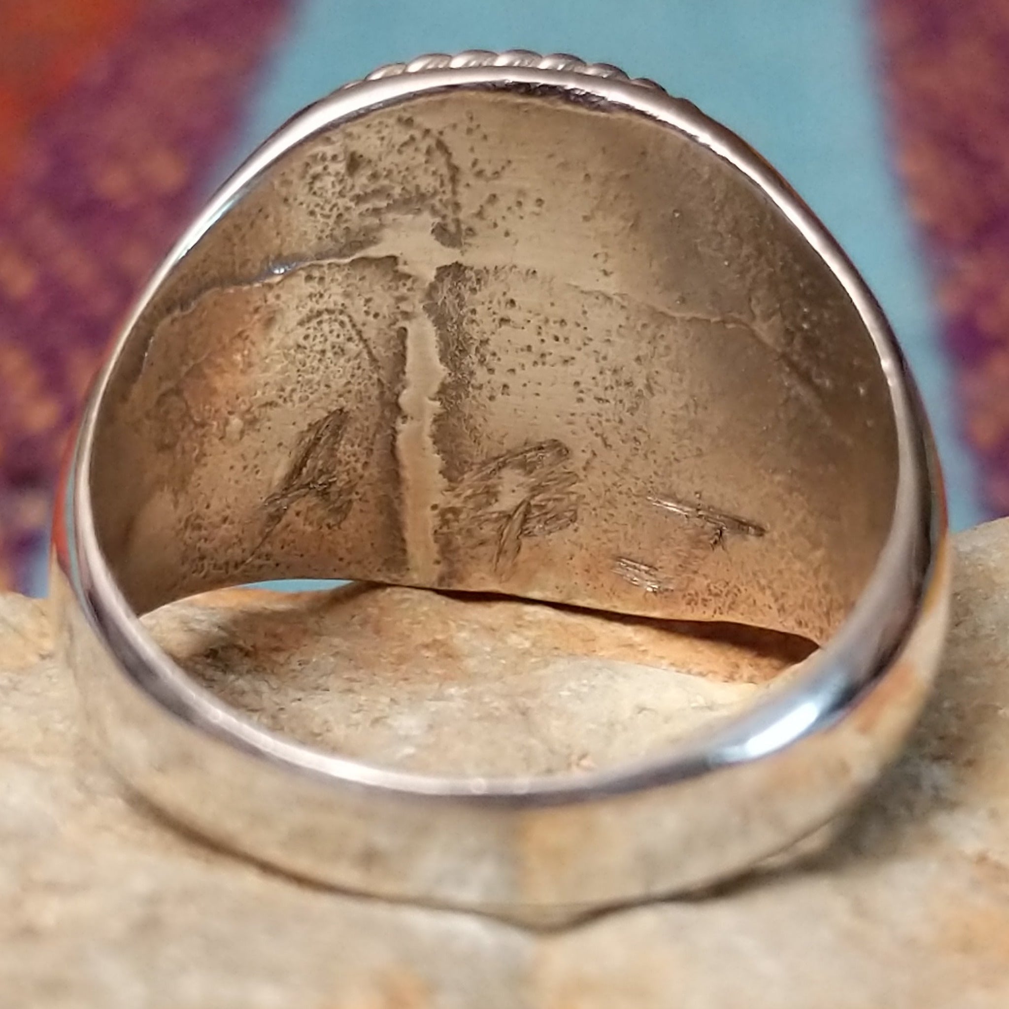 Navajo Circle Turquoise Ring by A.Q.J. featuring a large round blue turquoise cabochon with natural matrix, framed by twisted silver rope detailing on a polished silver band; artisan initials.
