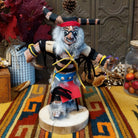 Navajo Ogre Kachina doll with gray fur-covered face, black horns with turquoise markings, open red mouth, pointed teeth, and green fabric apron.