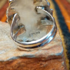 Close-up of the underside of a coral cluster ring showing the polished split-shank construction and stamped STERLING hallmark on the back of the setting.