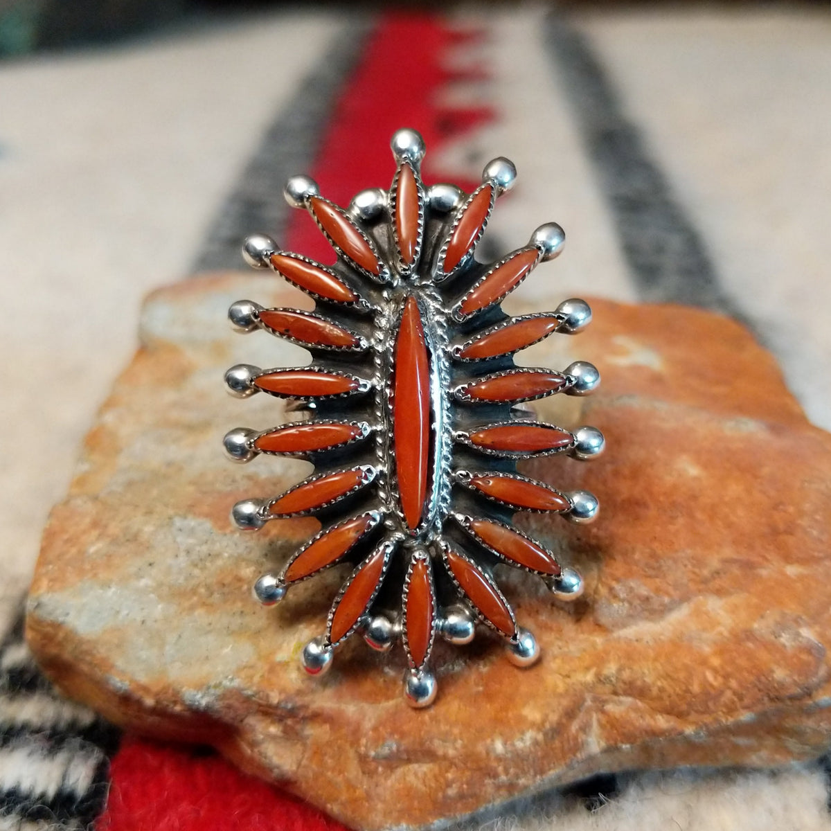 Navajo silver ring with radiating coral stones and silver drops.