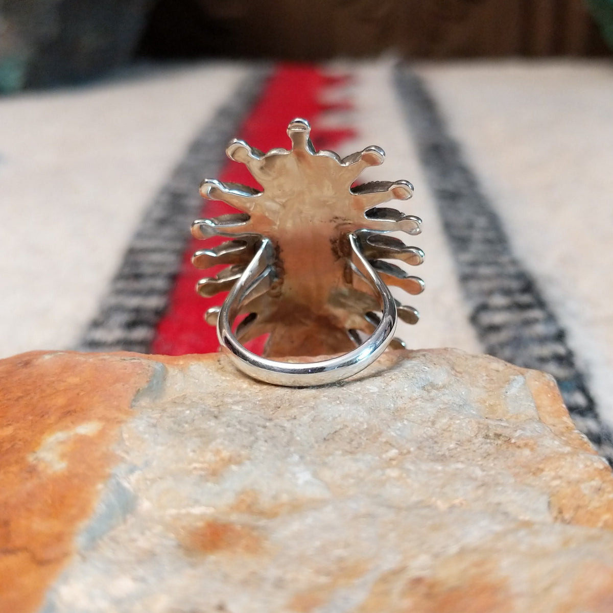 Navajo silver ring with radiating coral stones and silver drops.