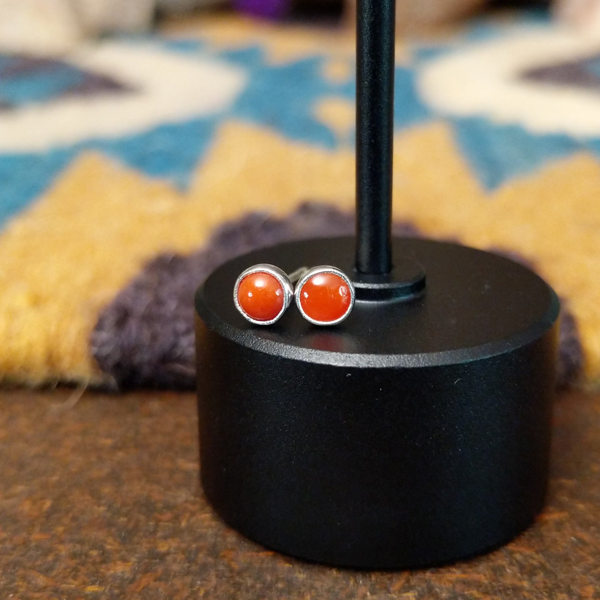 Handcrafted Navajo sterling silver stud earrings featuring round coral accents in polished silver.