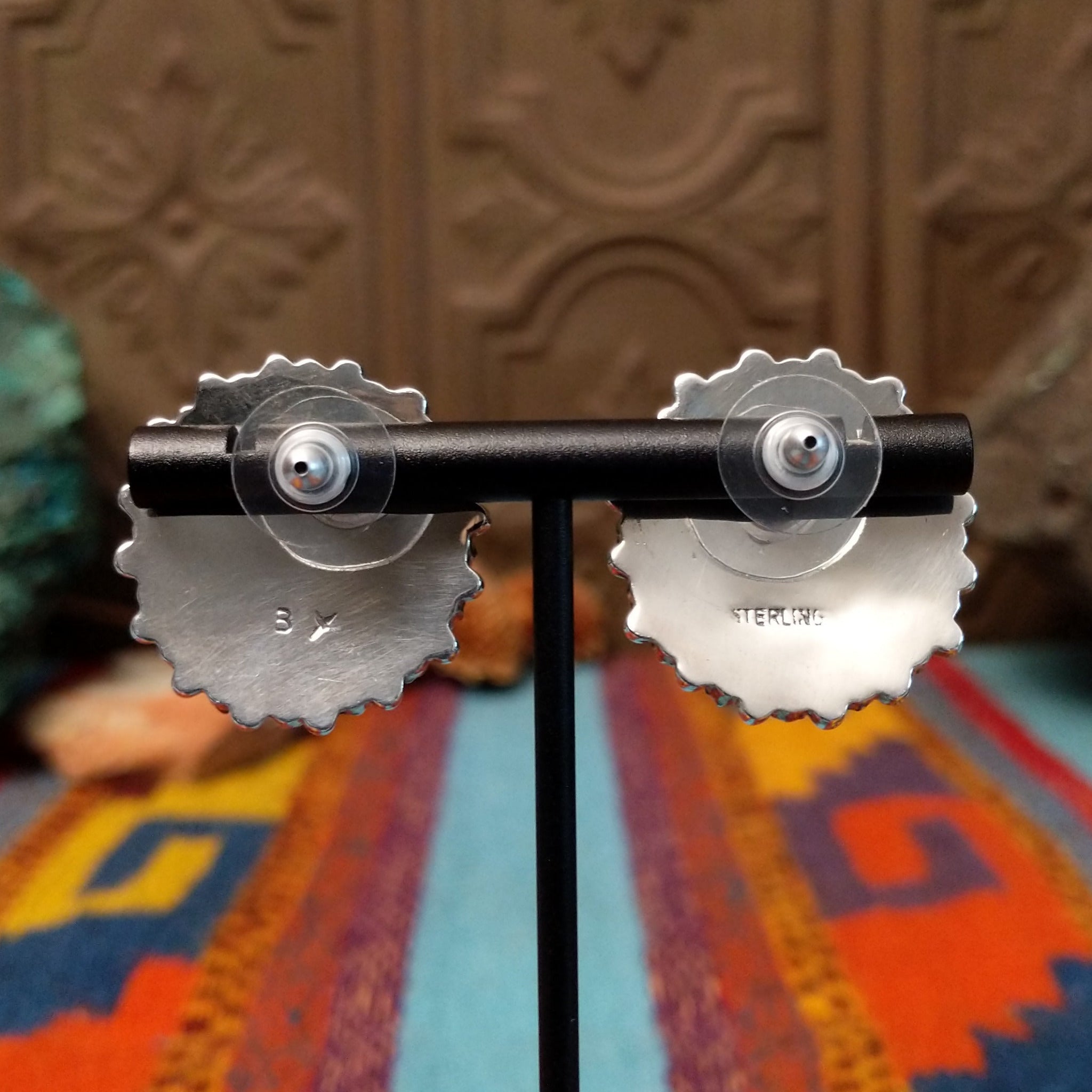 Navajo sterling silver matching earrings by B.Y., featuring numerous red-orange coral stones arranged in floral clusters; back side of earrings.
