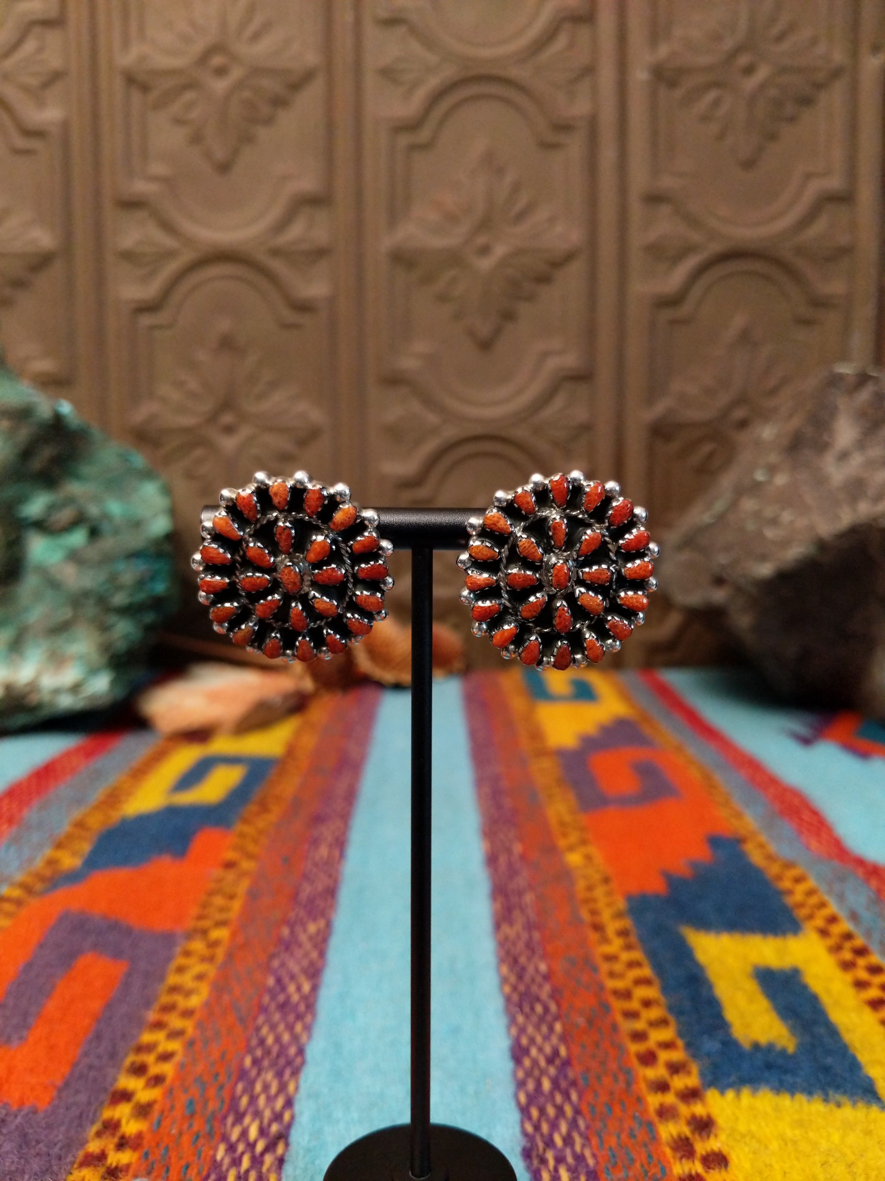 Navajo sterling silver matching earrings by B.Y., featuring numerous red-orange coral stones arranged in floral clusters.