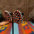 Navajo sterling silver matching earrings by B.Y., featuring numerous red-orange coral stones arranged in floral clusters.
