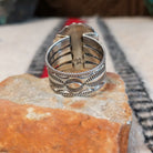 Navajo turquoise ring featuring a large oval bright blue turquoise stone with dark matrix, framed by twisted silver rope and an ornate scalloped silver setting; underside view.