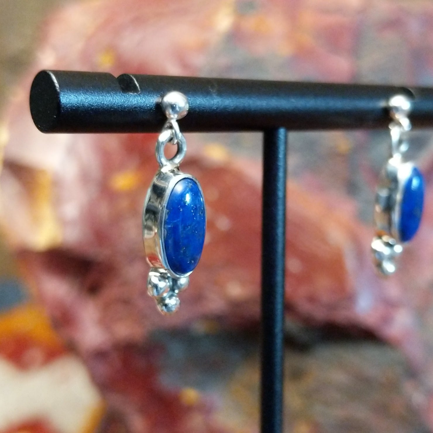 Sterling silver post earrings with lapis set in the bezels, framed by dotted accents.