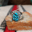 Navajo turquoise ring by S. with graduated silver drop accents.