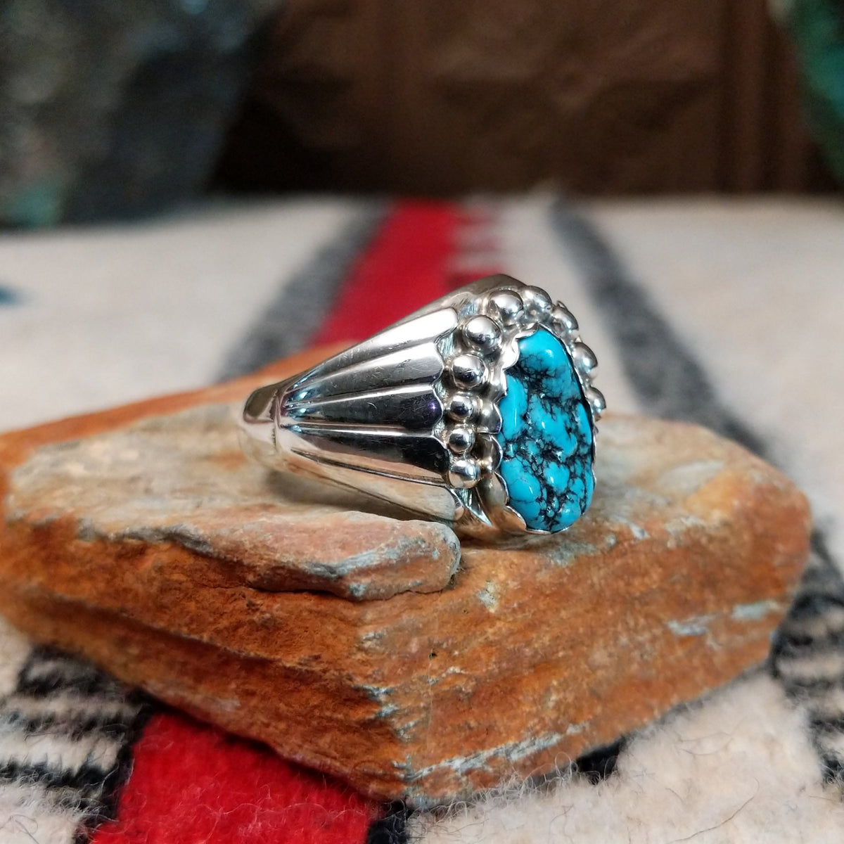 Navajo turquoise ring by S. with graduated silver drop accents.