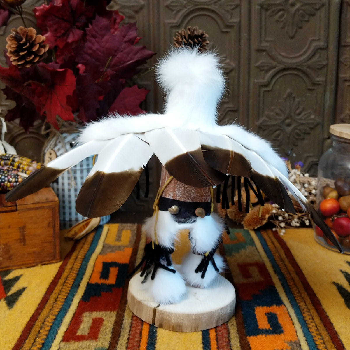Back view of the Navajo Eagle Kachina doll with wide outstretched white feather wings, white fur headdress, black painted facial markings, and white fabric apron.