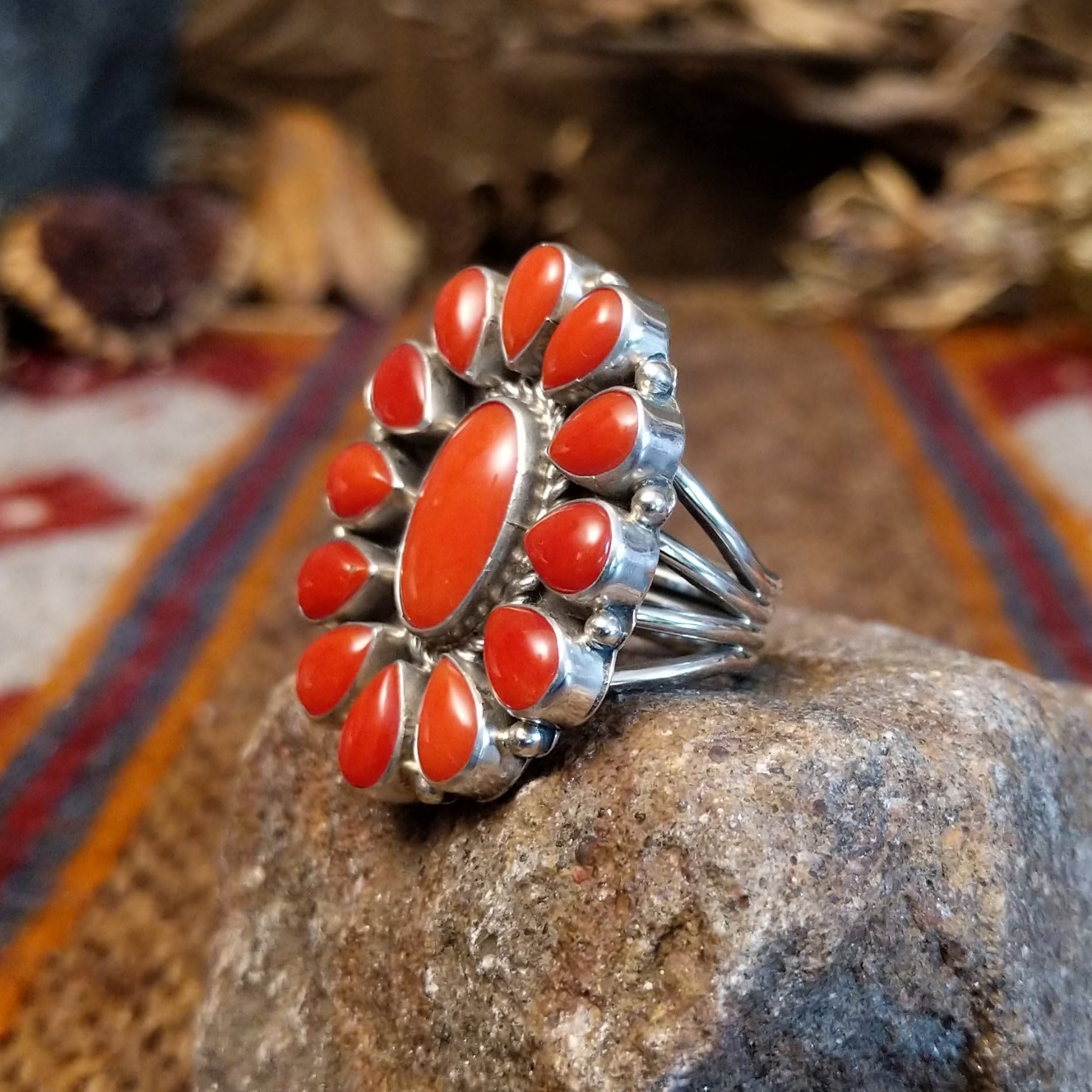 Sterling silver ring with coral set in the bezels creating a floral like motif and twisted rope accents around the center bezel.