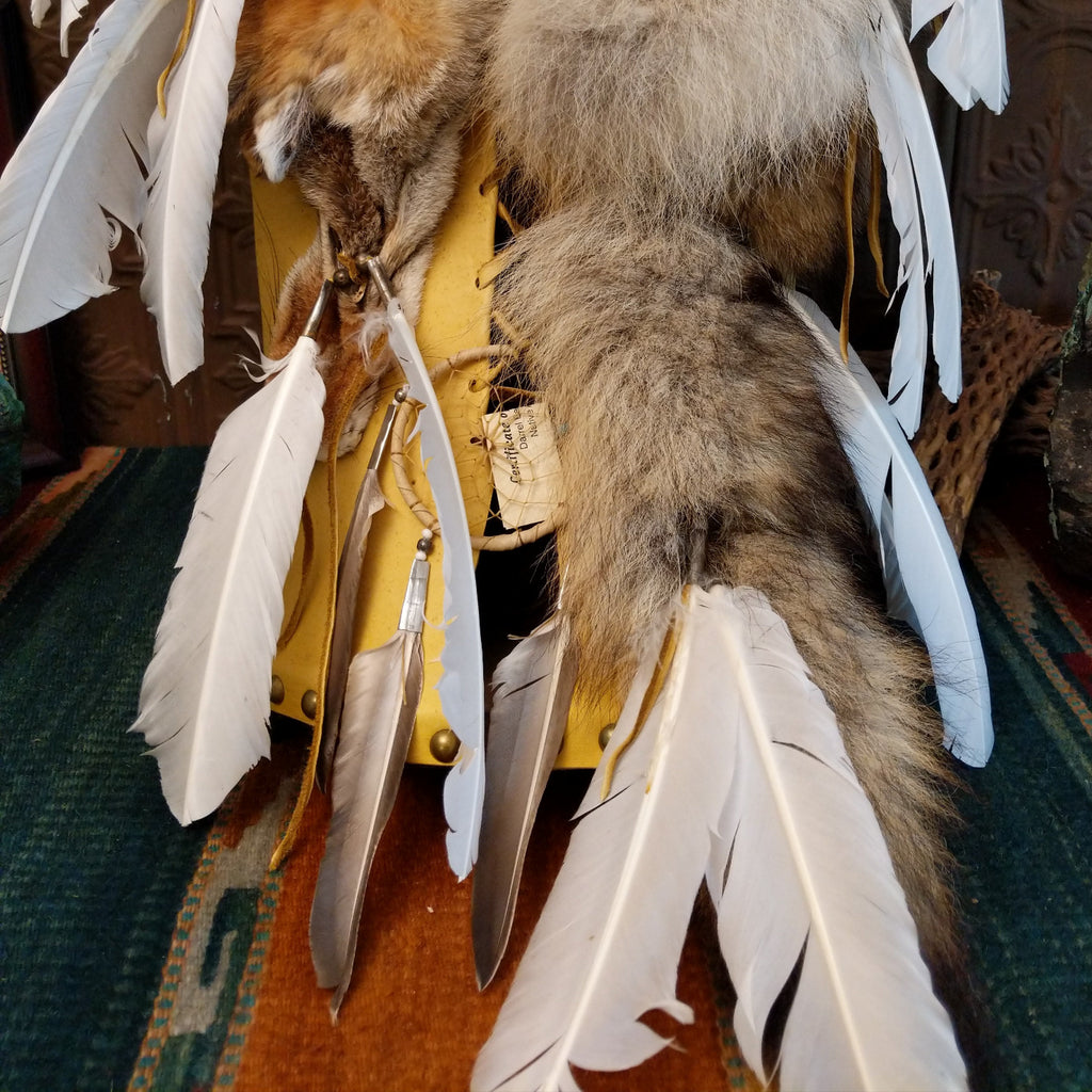 Fox fur, wood, and leather crafted into a cradlebaord with feathers and decorative beading.