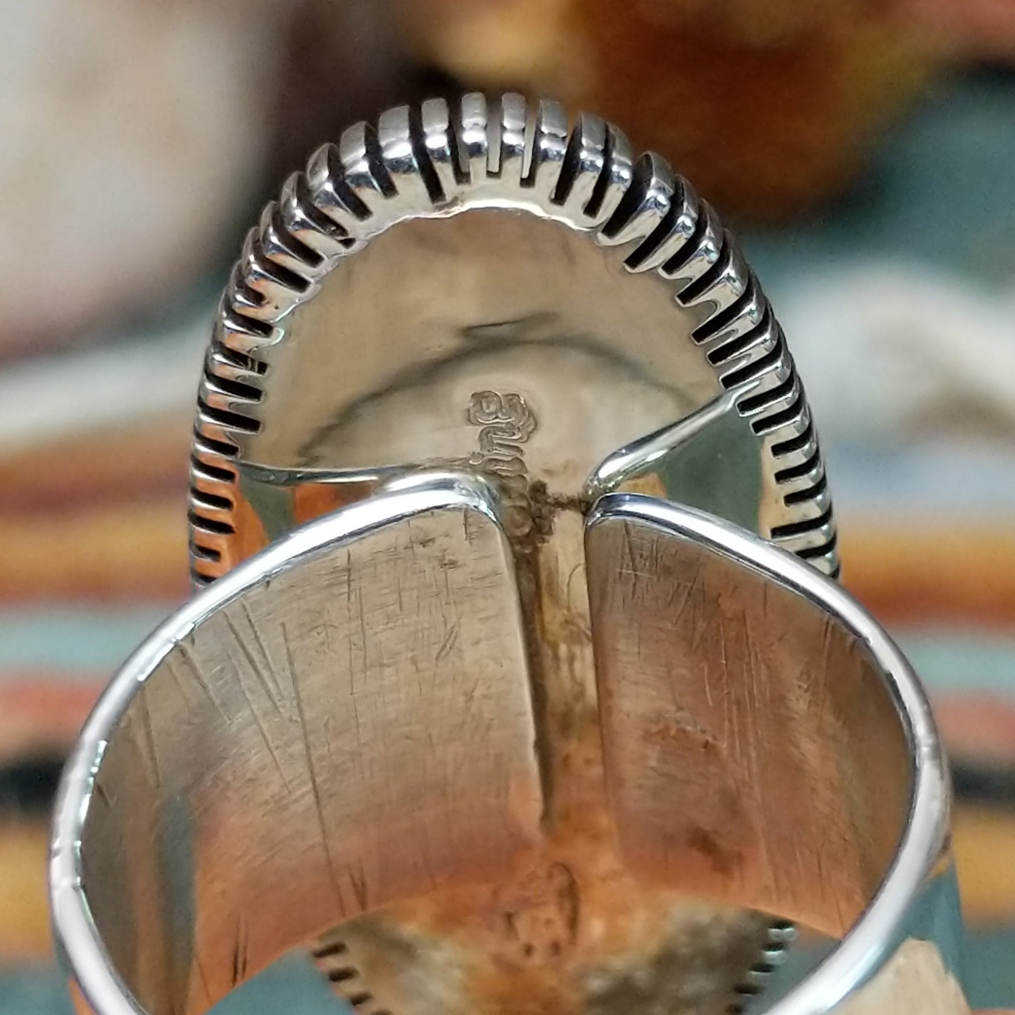 Navajo sterling silver ring featuring an elongated purple charoite stone framed by twisted silver rope and detailed radiating silverwork; artisan and Sterling Silver stamp.